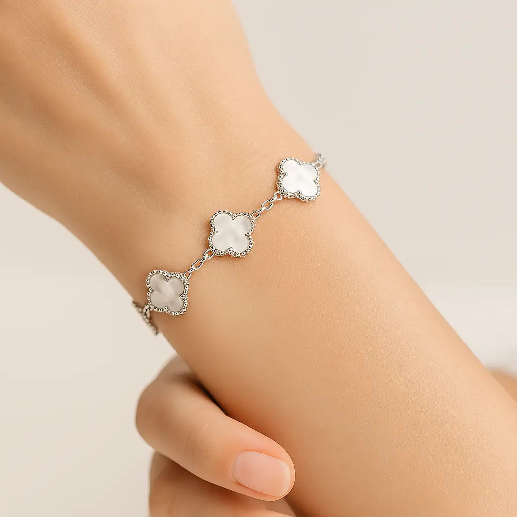 сребърна гривна с пет четирилистни детелини върху ръката на жена